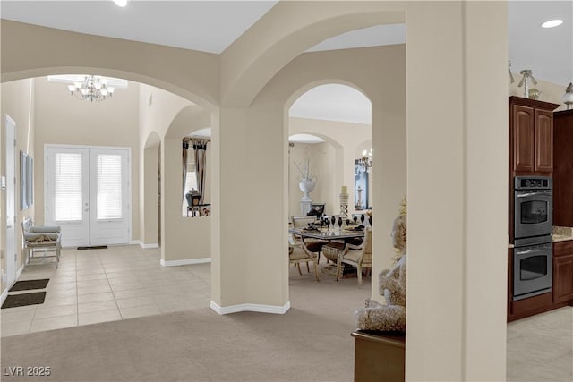 6739 Quapaw St, Las Vegas, NV 89149 - entrance foyer with a chandelier, arched walkways, light tile patterned floors, and light colored carpet