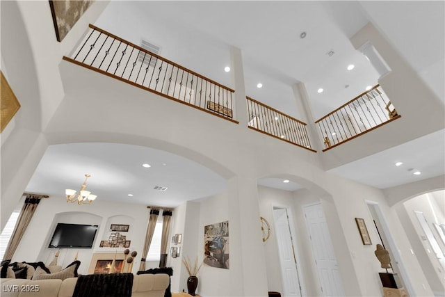 6739 Quapaw St, Las Vegas, NV 89149 - living area featuring arched walkways, a chandelier, a high ceiling, and recessed lighting