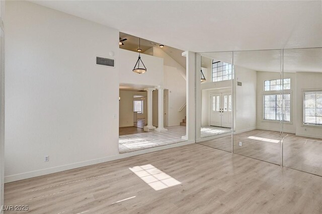 2917 Broken Willow Cir, Las Vegas, NV 89117 - unfurnished living room with decorative columns, high vaulted ceiling, baseboards, and wood finished floors