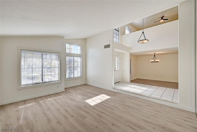 2917 Broken Willow Cir, Las Vegas, NV 89117 - unfurnished living room with wood finished floors, a chandelier, baseboards, and high vaulted ceiling