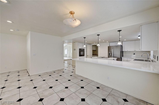2917 Broken Willow Cir, Las Vegas, NV 89117 - kitchen with stainless steel fridge, a sink, black oven, light countertops, and recessed lighting