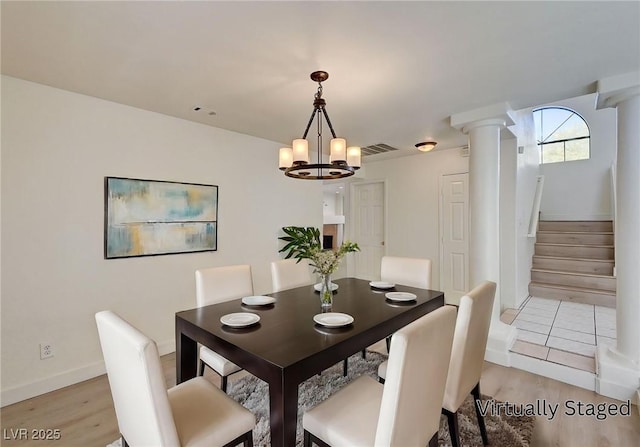 2917 Broken Willow Cir, Las Vegas, NV 89117 - dining space featuring light wood finished floors, stairway, a chandelier, decorative columns, and baseboards
