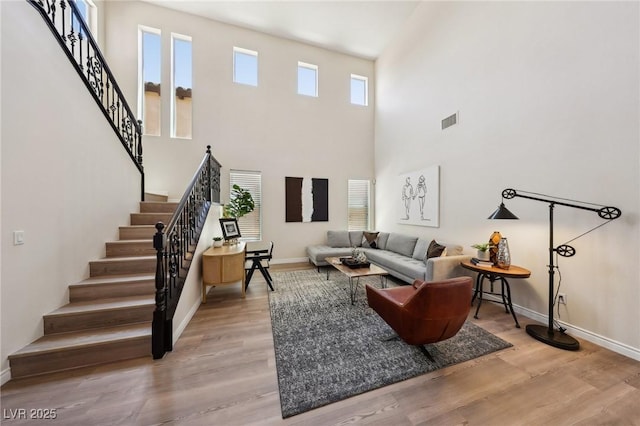 11707 Longworth Rd, Las Vegas, NV 89135 - living room with healthy amount of natural light, stairway, wood finished floors, baseboards, and a high ceiling
