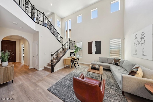 11707 Longworth Rd, Las Vegas, NV 89135 - living area featuring arched walkways, a towering ceiling, stairway, wood finished floors, and recessed lighting