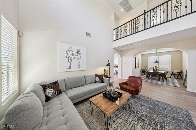11707 Longworth Rd, Las Vegas, NV 89135 - living room with arched walkways, a high ceiling, wood finished floors, and baseboards