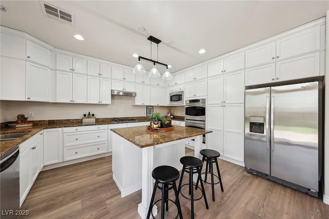 11707 Longworth Rd, Las Vegas, NV 89135 - kitchen with stainless steel appliances, white cabinetry, wood finished floors, and recessed lighting
