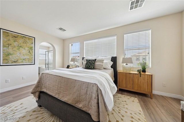 11707 Longworth Rd, Las Vegas, NV 89135 - bedroom featuring wood finished floors, arched walkways, baseboards, and connected bathroom