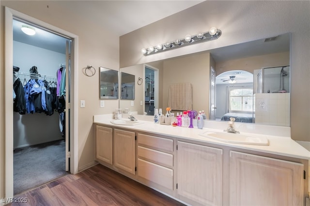 3950 S Sandhill Rd Unit 130, Las Vegas, NV 89121 - full bath with wood finished floors, double vanity, a walk in closet, and a shower with door