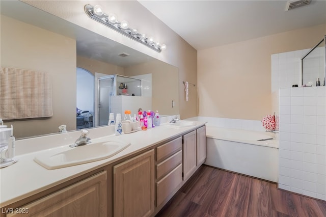 3950 S Sandhill Rd Unit 130, Las Vegas, NV 89121 - bathroom with a stall shower, double vanity, a garden tub, and wood finished floors
