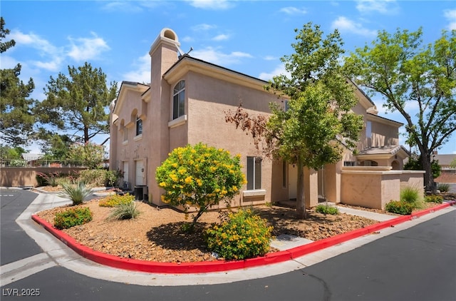 3950 S Sandhill Rd Unit 130, Las Vegas, NV 89121 - view of side of property with stucco siding, cooling unit, and a chimney