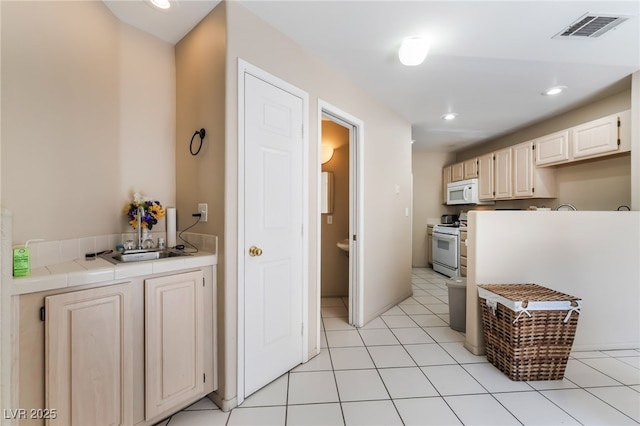 3950 S Sandhill Rd Unit 130, Las Vegas, NV 89121 - kitchen with white appliances, tile counters, recessed lighting, and a sink