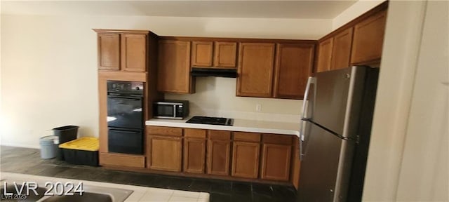 4821 Whisper Lake Ave, Las Vegas, NV 89131 - kitchen featuring black appliances, brown cabinets, under cabinet range hood, and light countertops