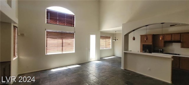 4821 Whisper Lake Ave, Las Vegas, NV 89131 - kitchen with stone tile flooring, baseboards, a high ceiling, light countertops, and under cabinet range hood