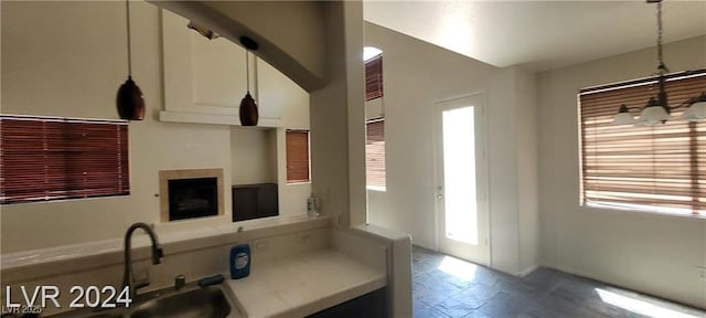4821 Whisper Lake Ave, Las Vegas, NV 89131 - kitchen featuring a sink, healthy amount of natural light, white cabinets, and decorative light fixtures