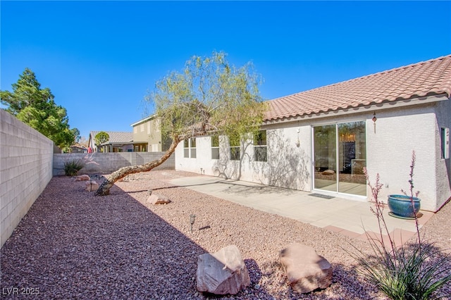 5653 Artesia Lake Ct, Las Vegas, NV 89118 - rear view of house with a tile roof, stucco siding, a fenced backyard, and a patio area