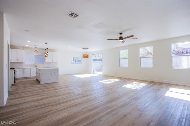 5653 Artesia Lake Ct, Las Vegas, NV 89118 - unfurnished living room featuring light wood-style floors, baseboards, a ceiling fan, a sink, and recessed lighting