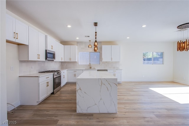 5653 Artesia Lake Ct, Las Vegas, NV 89118 - kitchen with appliances with stainless steel finishes, decorative backsplash, a sink, white cabinetry, and recessed lighting