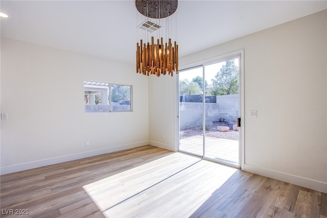 5653 Artesia Lake Ct, Las Vegas, NV 89118 - unfurnished dining area featuring light wood-style flooring, baseboards, and a chandelier