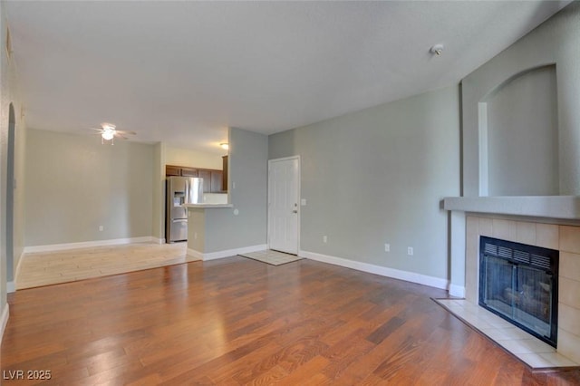 1405 S Nellis Blvd Unit 2117, Las Vegas, NV 89104 - unfurnished living room featuring a fireplace, a ceiling fan, wood finished floors, and baseboards