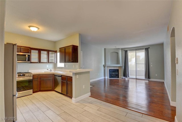 1405 S Nellis Blvd Unit 2117, Las Vegas, NV 89104 - kitchen with stainless steel appliances, light wood-type flooring, open floor plan, and a peninsula