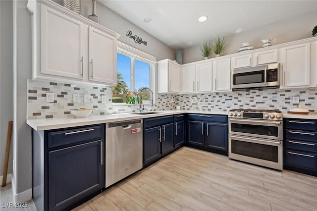 2425 Sturrock Dr, Henderson, NV 89044 - kitchen with appliances with stainless steel finishes, a sink, blue cabinets, white cabinets, and light countertops