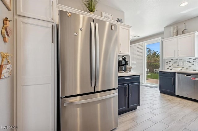 2425 Sturrock Dr, Henderson, NV 89044 - kitchen featuring appliances with stainless steel finishes, decorative backsplash, white cabinets, light countertops, and blue cabinetry