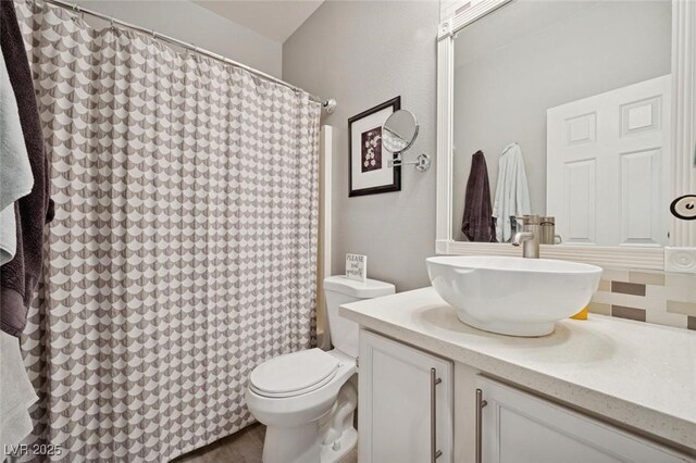 2425 Sturrock Dr, Henderson, NV 89044 - full bathroom featuring vanity, toilet, backsplash, and curtained shower