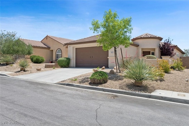 2425 Sturrock Dr, Henderson, NV 89044 - mediterranean / spanish house with stucco siding, a fenced front yard, an attached garage, concrete driveway, and a tile roof