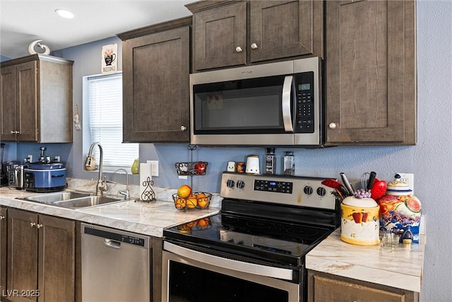 320 W Van Buren Ave, Las Vegas, NV 89106 - kitchen featuring appliances with stainless steel finishes, a sink, dark brown cabinets, and light countertops