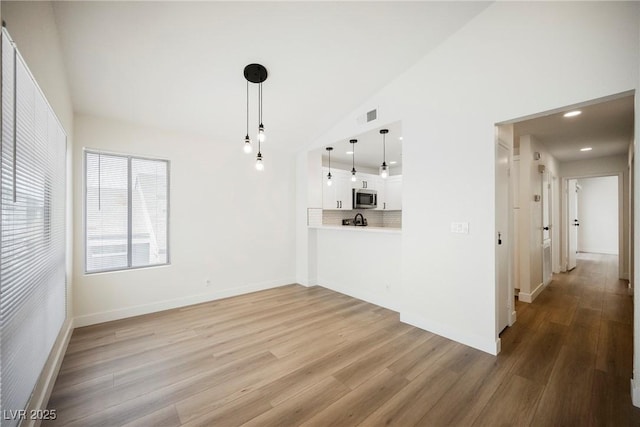 5516 Orchard Ln Unit 0, Las Vegas, NV 89110 - unfurnished living room featuring light wood-style floors, recessed lighting, baseboards, and high vaulted ceiling