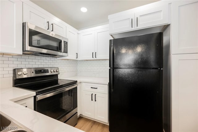 5516 Orchard Ln Unit 0, Las Vegas, NV 89110 - kitchen with stainless steel appliances, white cabinetry, decorative backsplash, light wood-style floors, and recessed lighting