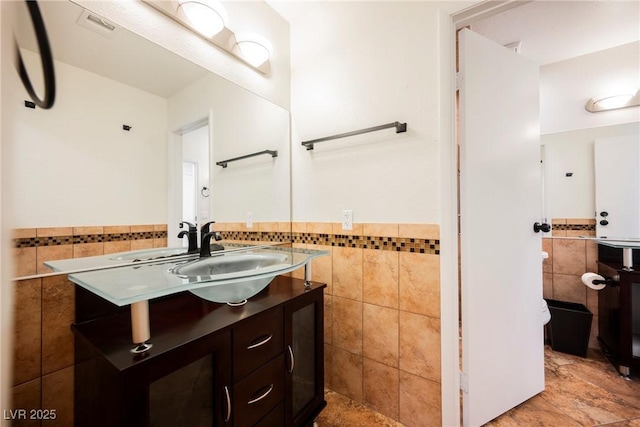 5516 Orchard Ln Unit 0, Las Vegas, NV 89110 - bathroom with tile walls, vanity, wainscoting, and toilet