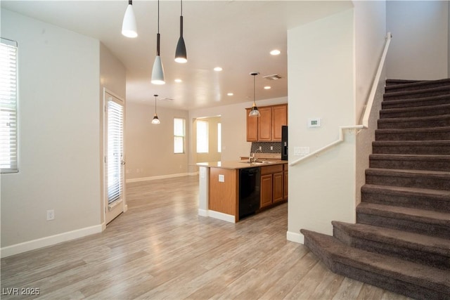 7715 Peaceful Trellis Dr, Las Vegas, NV 89179 - kitchen featuring dishwasher, light countertops, open floor plan, light wood-style flooring, and decorative backsplash