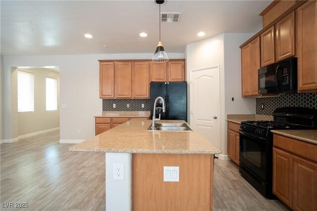 7715 Peaceful Trellis Dr, Las Vegas, NV 89179 - kitchen with black appliances, a sink, tasteful backsplash, a center island with sink, and baseboards