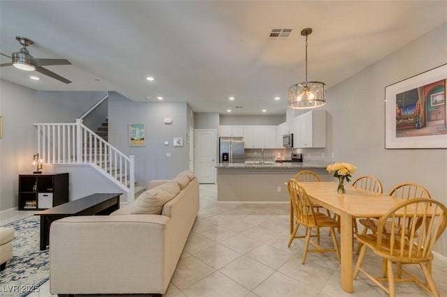 2870 Turnstone Ridge St, Henderson, NV 89044 - living room featuring stairway, ceiling fan, recessed lighting, light tile patterned flooring, and a chandelier