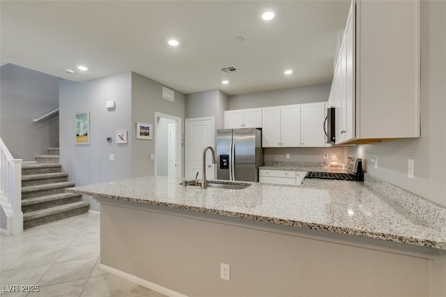 2870 Turnstone Ridge St, Henderson, NV 89044 - kitchen featuring stainless steel appliances, a sink, a peninsula, light stone counters, and recessed lighting