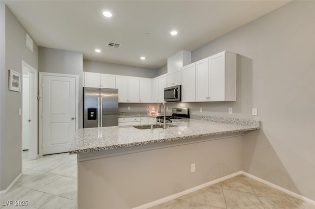 2870 Turnstone Ridge St, Henderson, NV 89044 - kitchen with appliances with stainless steel finishes, a sink, a peninsula, light stone counters, and white cabinets