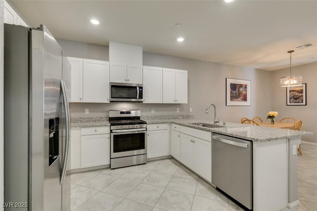 2870 Turnstone Ridge St, Henderson, NV 89044 - kitchen with appliances with stainless steel finishes, a sink, white cabinets, recessed lighting, and a peninsula