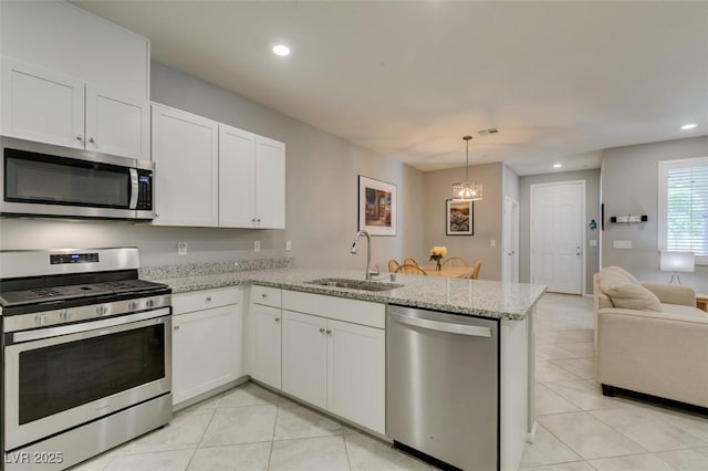 2870 Turnstone Ridge St, Henderson, NV 89044 - kitchen with appliances with stainless steel finishes, a sink, a peninsula, light tile patterned floors, and recessed lighting