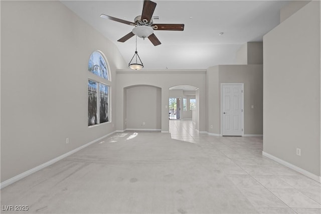 2158 Shubert Ave, Henderson, NV 89052 - spare room featuring arched walkways, ceiling fan, baseboards, high vaulted ceiling, and light colored carpet