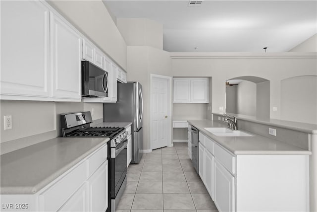 2158 Shubert Ave, Henderson, NV 89052 - kitchen with appliances with stainless steel finishes, a sink, white cabinetry, light countertops, and light tile patterned floors