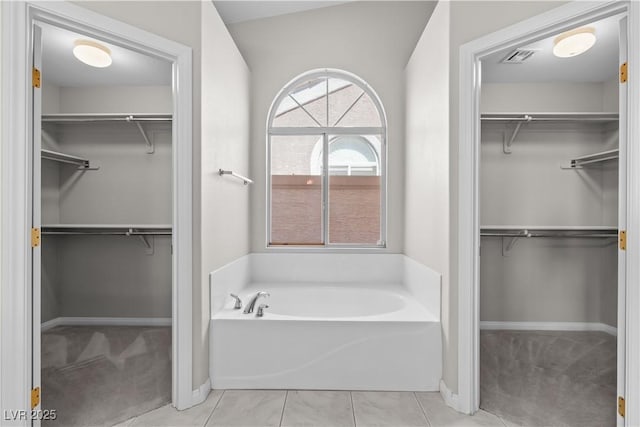 2158 Shubert Ave, Henderson, NV 89052 - bathroom with a bath, a walk in closet, baseboards, and tile patterned floors