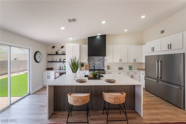 9705 Standard Ave, Las Vegas, NV 89129 - kitchen featuring high quality fridge, open shelves, a breakfast bar, light countertops, and white cabinetry