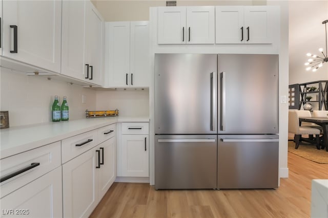 9705 Standard Ave, Las Vegas, NV 89129 - kitchen with high quality fridge, light wood-type flooring, light countertops, and white cabinetry