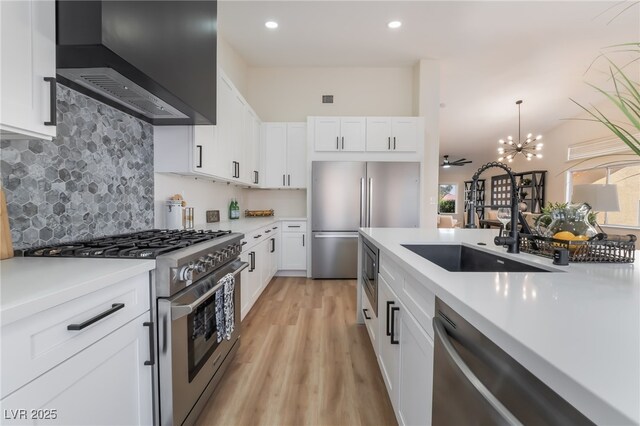9705 Standard Ave, Las Vegas, NV 89129 - kitchen with appliances with stainless steel finishes, a sink, wall chimney exhaust hood, light countertops, and recessed lighting