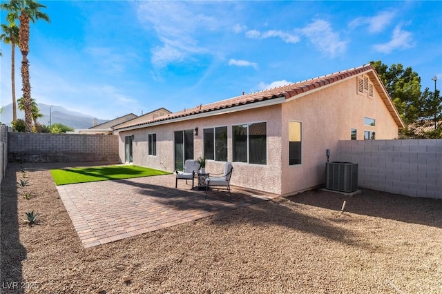 9705 Standard Ave, Las Vegas, NV 89129 - back of property featuring stucco siding, a fenced backyard, central AC unit, a mountain view, and a tile roof