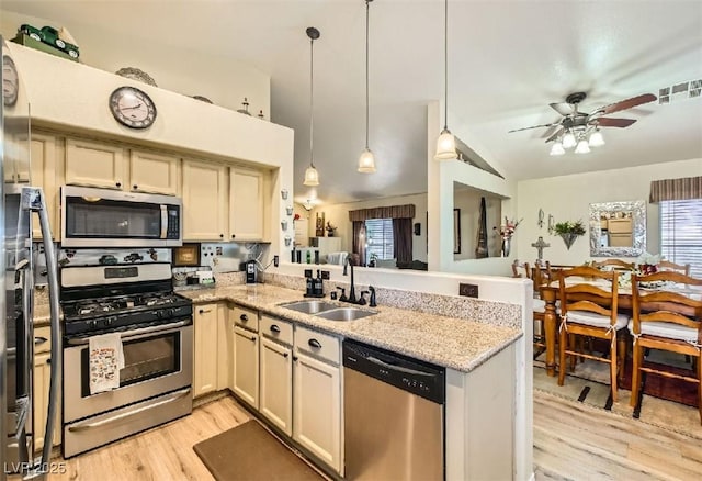 3473 Conough Ln, Las Vegas, NV 89129 - kitchen featuring stainless steel appliances, a sink, a peninsula, a ceiling fan, and light wood finished floors
