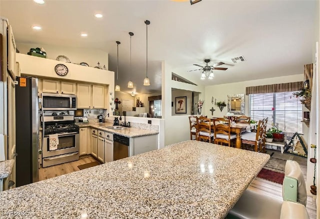 3473 Conough Ln, Las Vegas, NV 89129 - kitchen with appliances with stainless steel finishes, a peninsula, light wood finished floors, light stone counters, and a sink