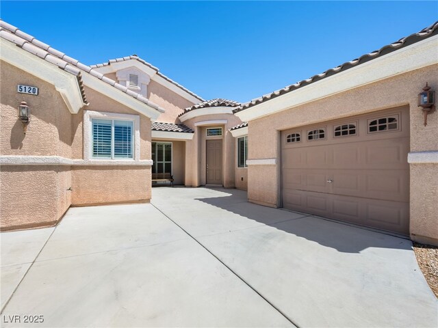 5120 Mirage Garden St, Las Vegas, NV 89130 - view of front facade with a tiled roof, stucco siding, concrete driveway, and an attached garage