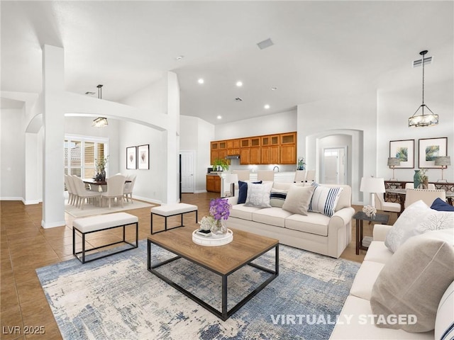 5120 Mirage Garden St, Las Vegas, NV 89130 - tiled living area with arched walkways, baseboards, a chandelier, high vaulted ceiling, and recessed lighting